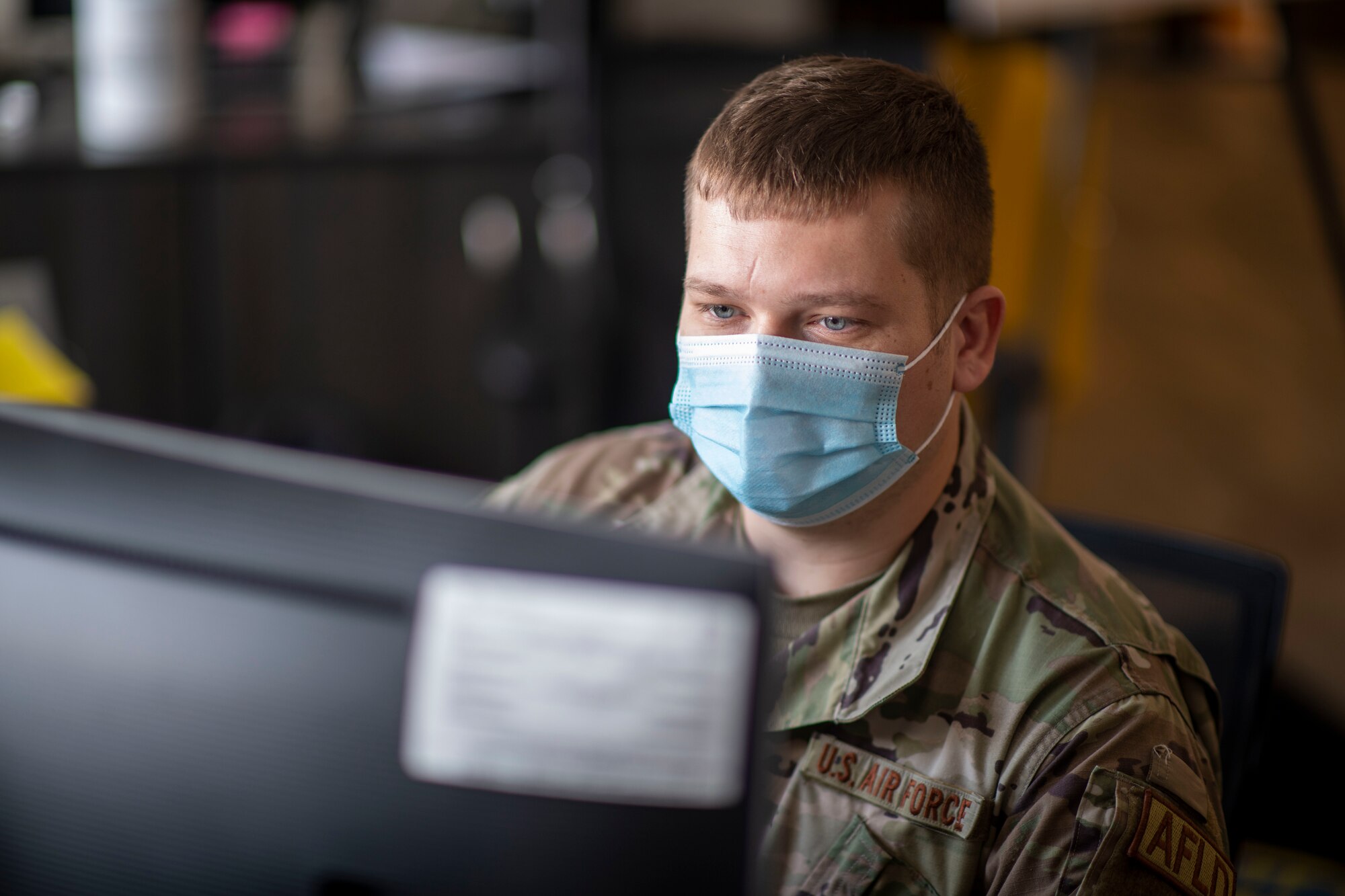 Airman looks at a computer screen