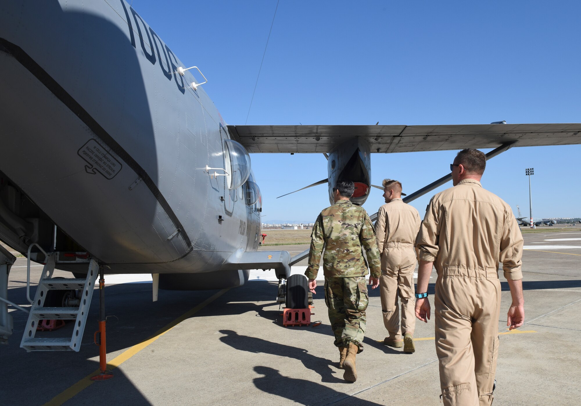 American and Polish military members standing on flightline