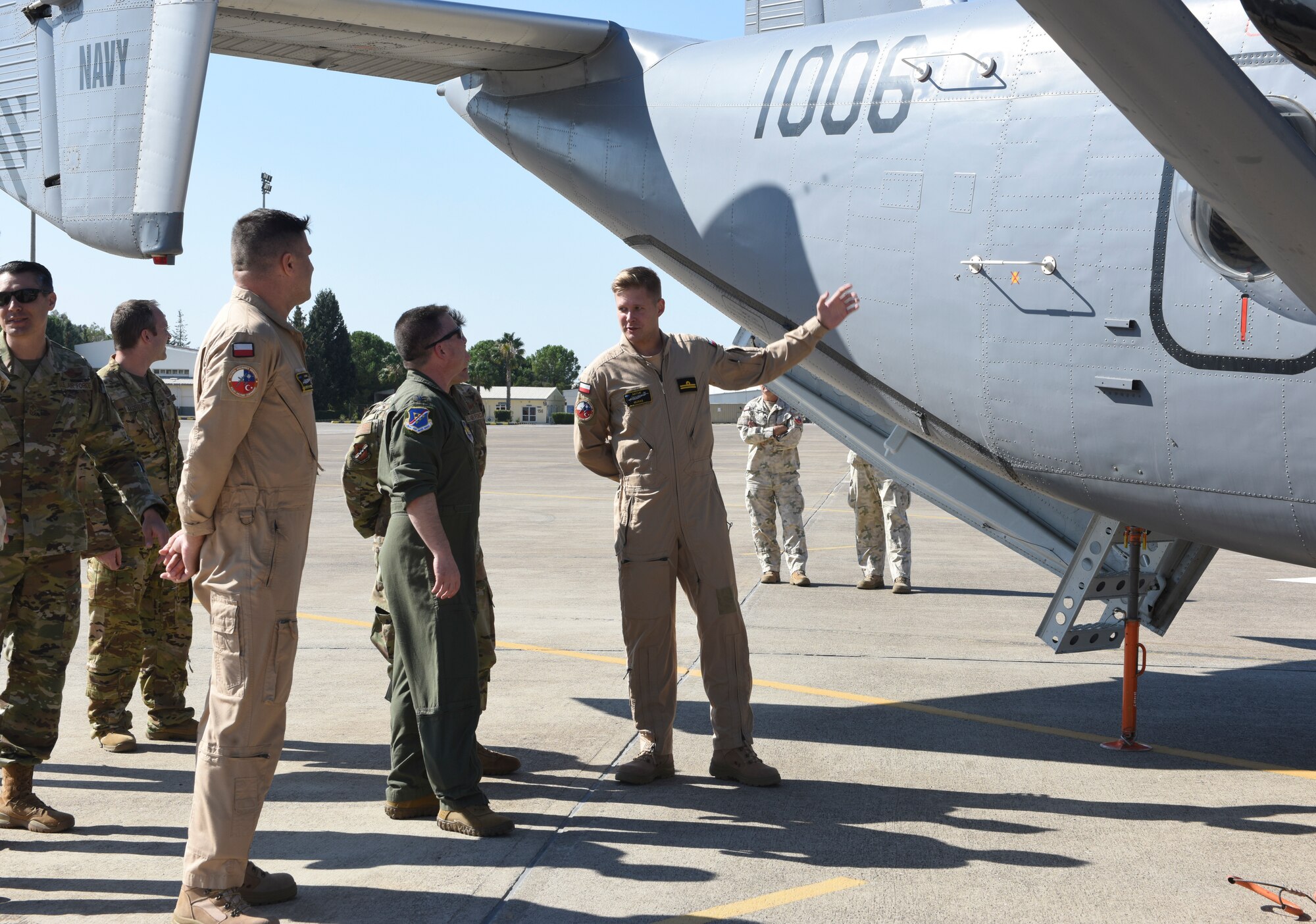 American and Polish military members standing on flightline