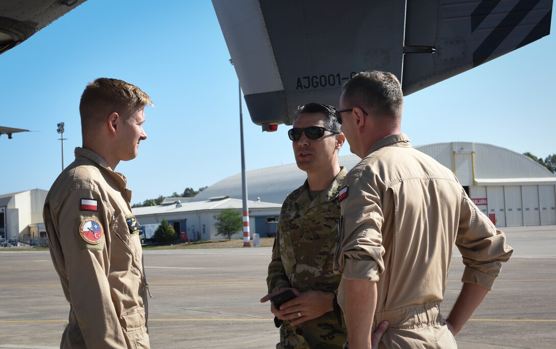 American and Polish military members standing on flightline
