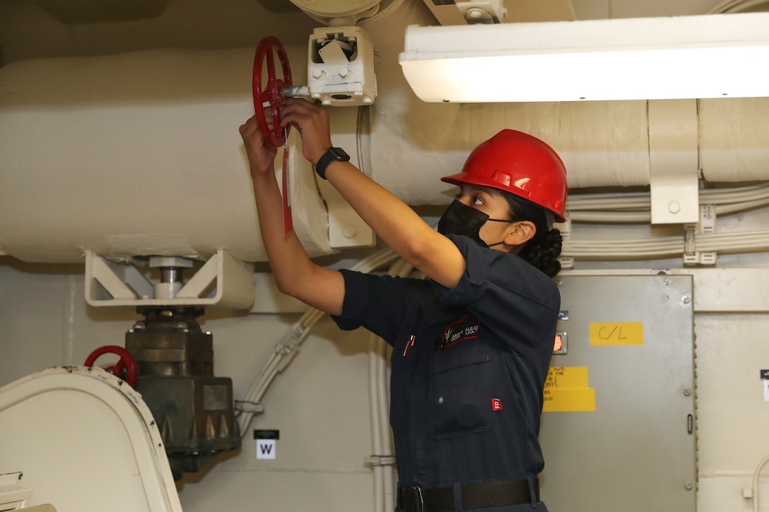 A sailor puts a tag on a device.