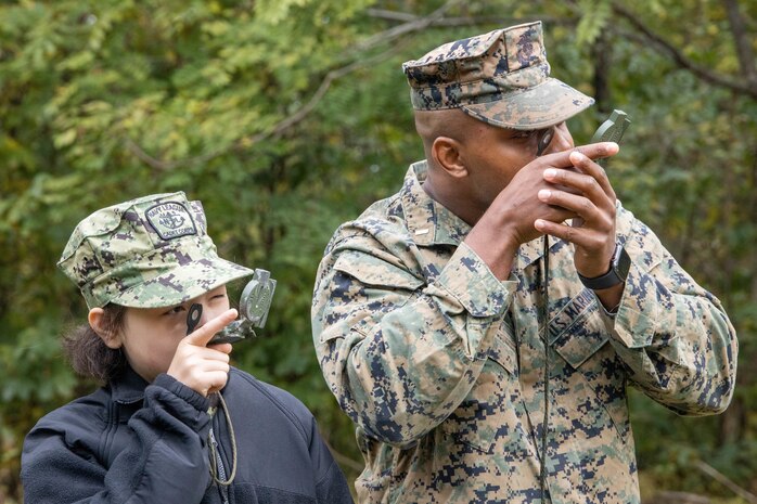 U.S. Marine Corps 1st Lt. Amos R. Mason, Head of Naval Enlisted Programs, guides a naval sea cadet on how to properly use a compass at Marine Corps Base Quantico, Oct. 23, Va. Marine Corps Recruiting Command volunteered to provide mentorship and training during the U.S. Naval Sea Cadet Corps' three-day field training exercise. (U.S Marine Corps photo by Lance Cpl. Gustavo Romero)