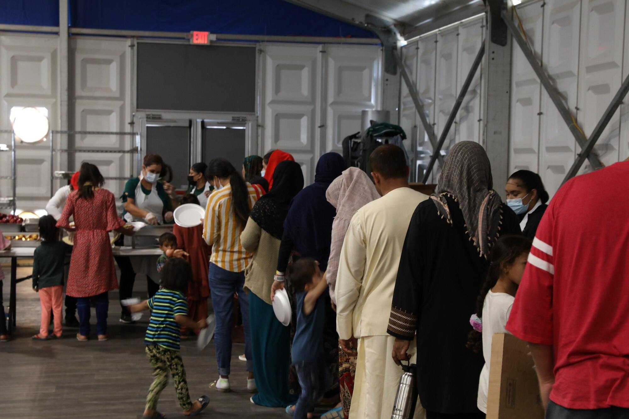Afghan evacuees receive food at their new dining facility at Aman Omid Village Oct. 20, 2021, at Holloman Air Force, New Mexico. The Department of Defense, through the U.S. Northern Command, and in support of the Department of State and Department of Homeland Security, is providing transportation, temporary housing, medical screening, and general support for at least 50,000 Afghan evacuees at suitable facilities, in permanent or temporary structures, as quickly as possible. This initiative provides Afghan evacuees essential support at secure locations outside Afghanistan. (U.S. Army photo by Spc. Jose Escamilla)