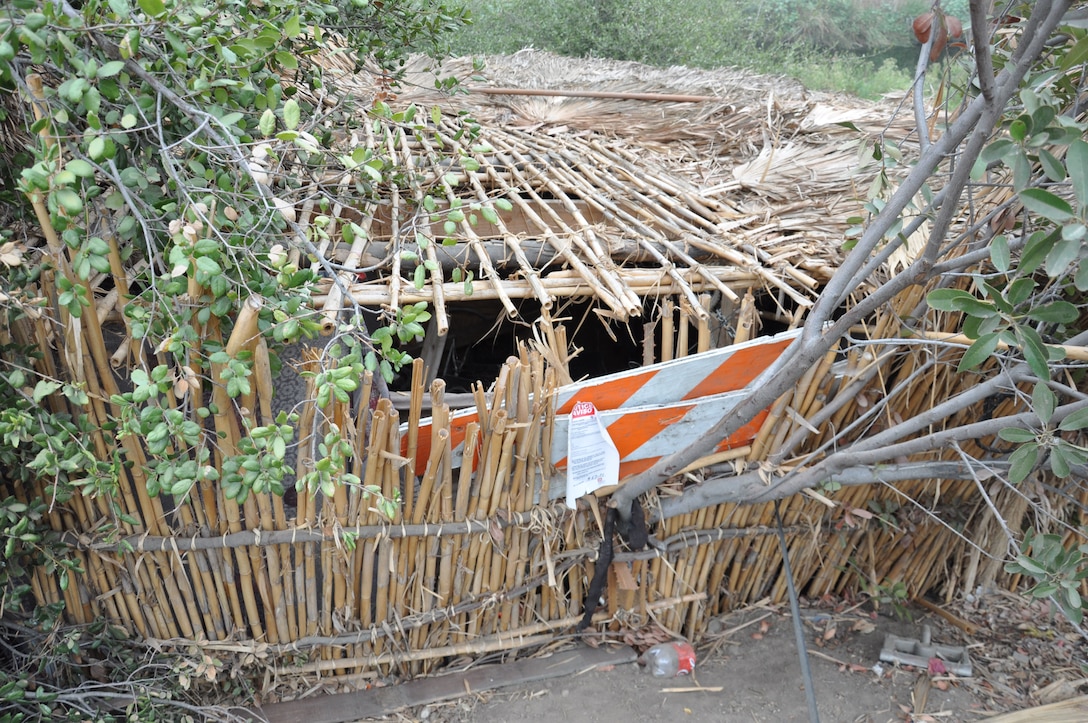 An abandoned Arundo donax hut partially hidden on the wooded bank is revealed as contracted workers removed tons of trash from San Jose Creek. Arundo is an invasive giant reed that grows very fast. The U.S. Army Corps of Engineers Los Angeles District cleared 575 tons of debris from about 120 acres of riverbank, Sept. 27-Oct. 22, 2021.