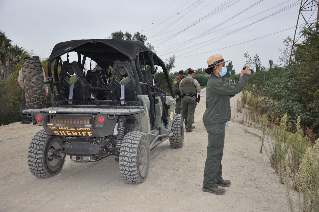 U.S. Army Corps of Engineers Los Angeles District Ranger Annel Monsalvo documents a debris field as LA County Sheriff deputies sweep the 120 acres of riverbank to be cleaned up. The Corps Los Angeles District cleared about 120 acres of riverbank, Sept. 27-Oct. 22, 2021.