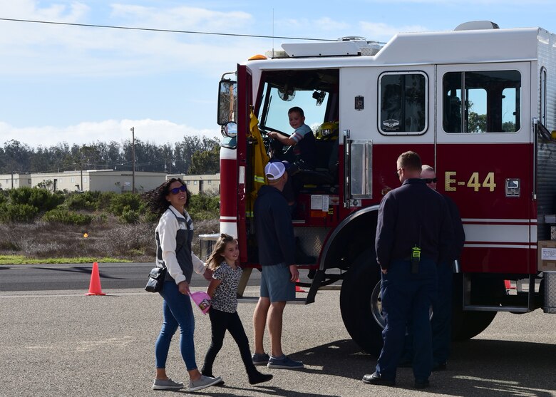 Vandenberg fire fighters offer children the opportunity to see the inside of a fire truck during the Ninth Annual Exotic Car Show Oct. 23, 2021, at Vandenberg Space Force Base, Calif. The 30th Force Support Squadron collaborates with the fire department on base to allow children to see how a fire truck operates. (U.S. Space Force photo by Airman First Class Tiarra Sibley)