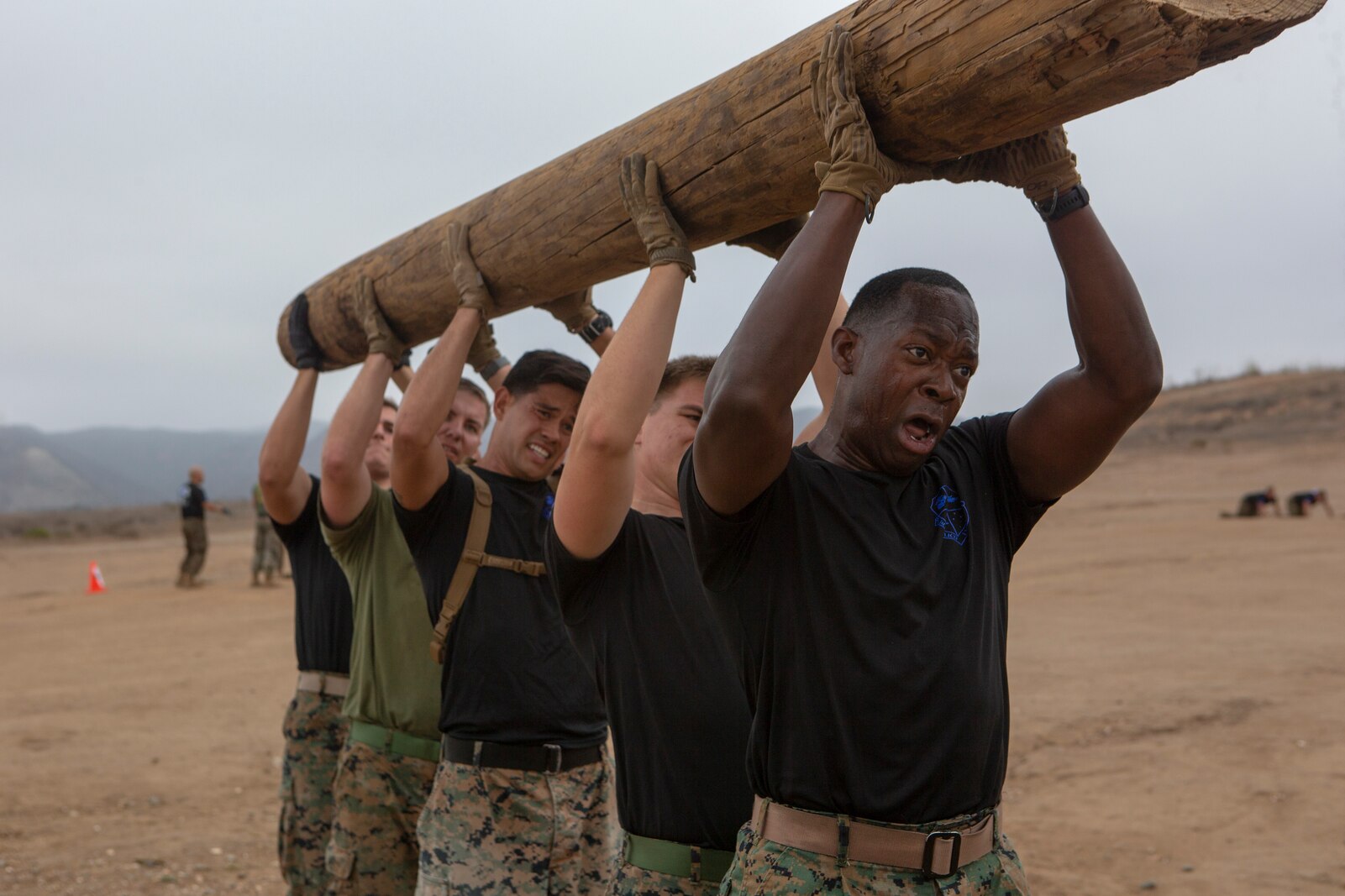 U.S. Marines with 1st Air Naval Gunfire Liaison Company, I Marine Expeditionary Force Information Group, lift a log during a physical training event at Marine Corps Base Camp Pendleton, California, Sept. 3, 2021. Marines participate in physically challenging events to improve their physical fitness and build unit cohesion. (U.S Marine Corps photo by Cpl. Nicolas Atehortua)