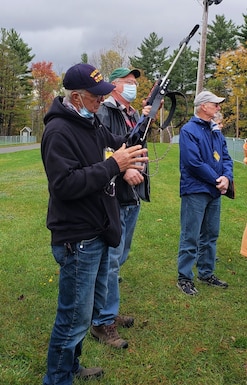 Tour participants handle a rifle used by biathletes in competition at Camp Ethan Allen Training Site, Oct. 22, 2021. Military retirees and neighbors of the range, among others, participated in a public tour of CEATS where they received an overview of range operations and visited military barracks; construction of a new Army Mountain Warfare School; weapon ranges; and the biathlon program. (U.S. Army photo by Maj. J. Scott Detweiler)