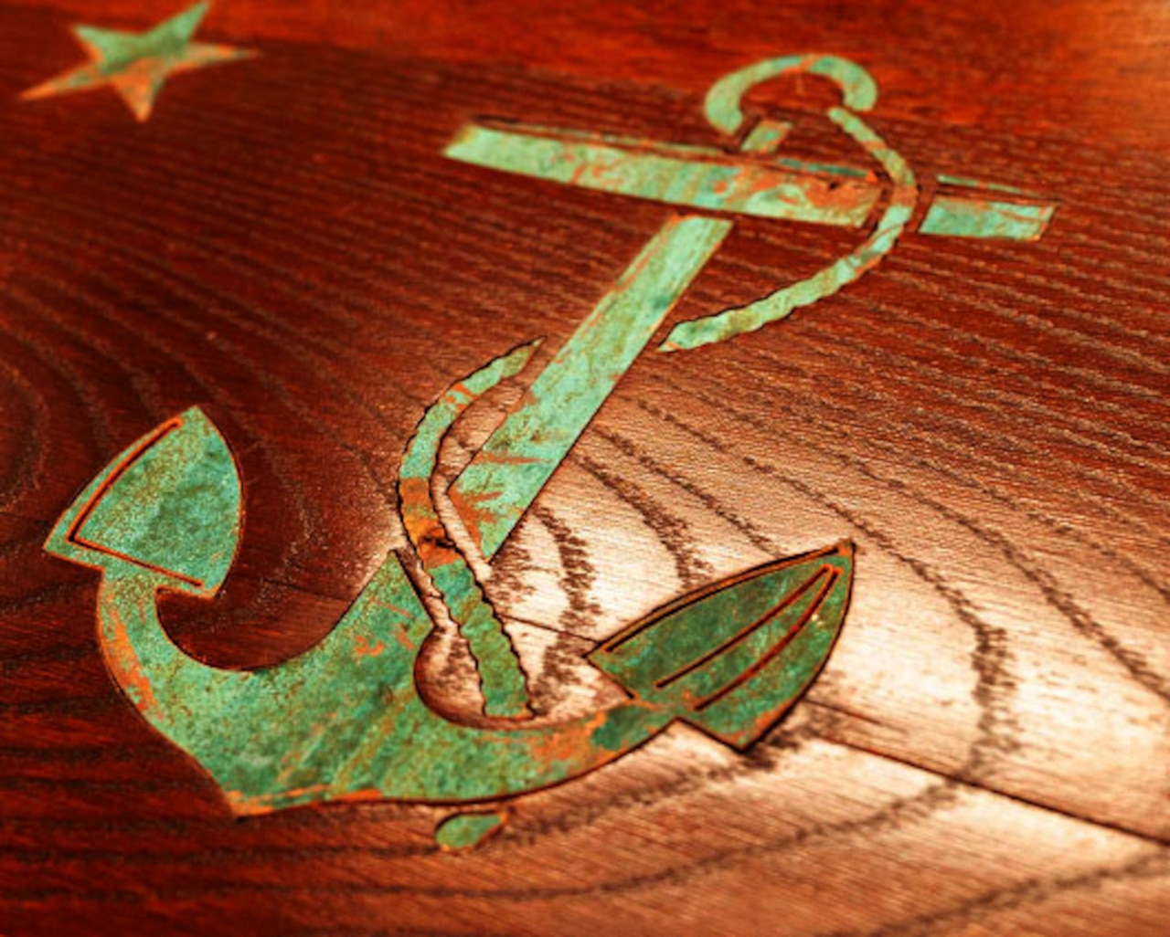 A metal anchor inlay on a desk.