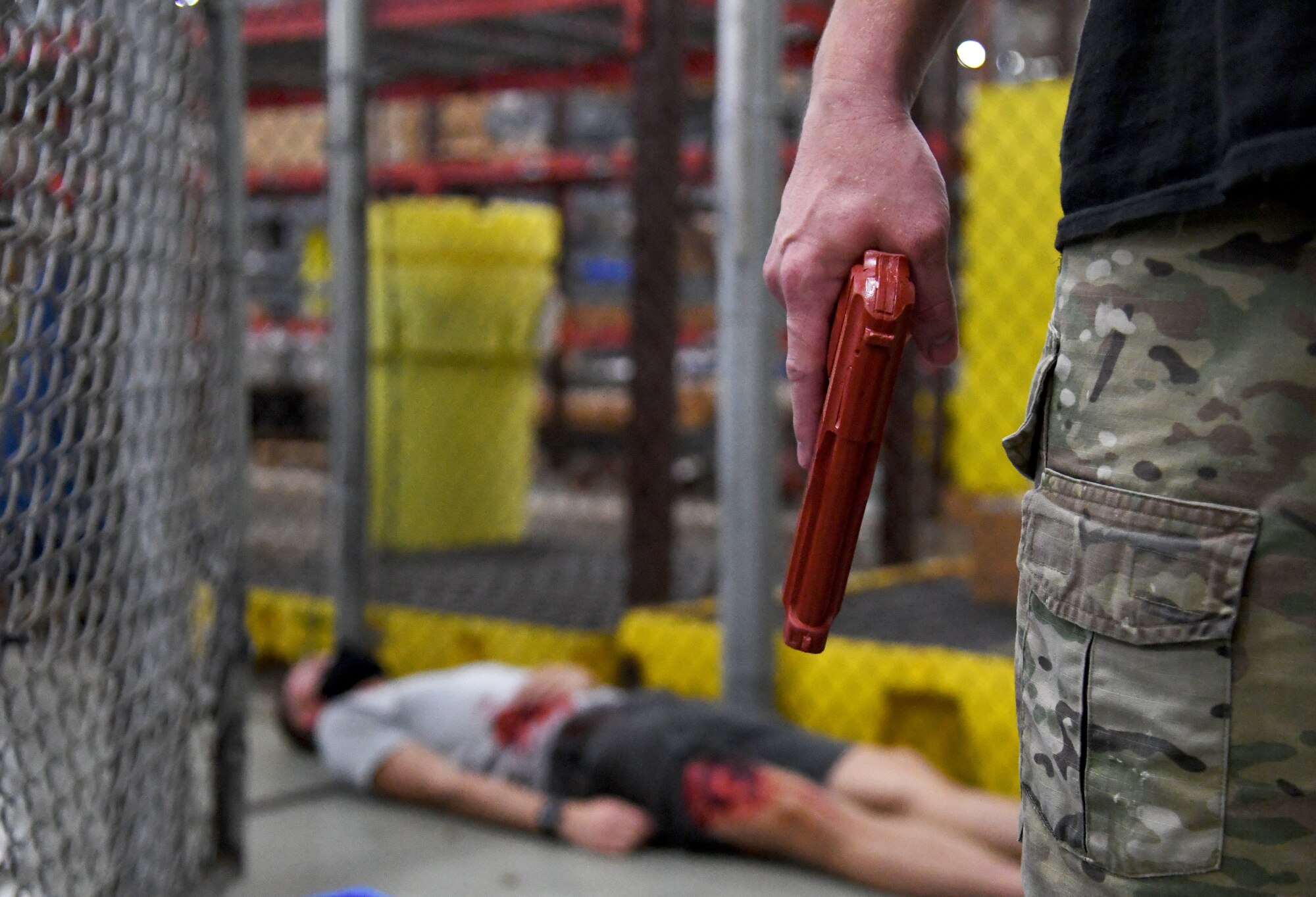 U.S. Air Force Staff Sgt. Matthew Storer, 81st Training Support Squadron force development NCO in charge, portrays an active shooter as Airman Basic Ethan Carter, 336th Training Squadron student, portrays a victim during an active shooter exercise inside the Taylor Logistics Center at Keesler Air Force Base, Mississippi, Oct. 21, 2021. The scenario included an active duty Air Force member who simulated open fire in order to test the base's ability to respond to and recover from a mass casualty event. (U.S. Air Force photo by Kemberly Groue)