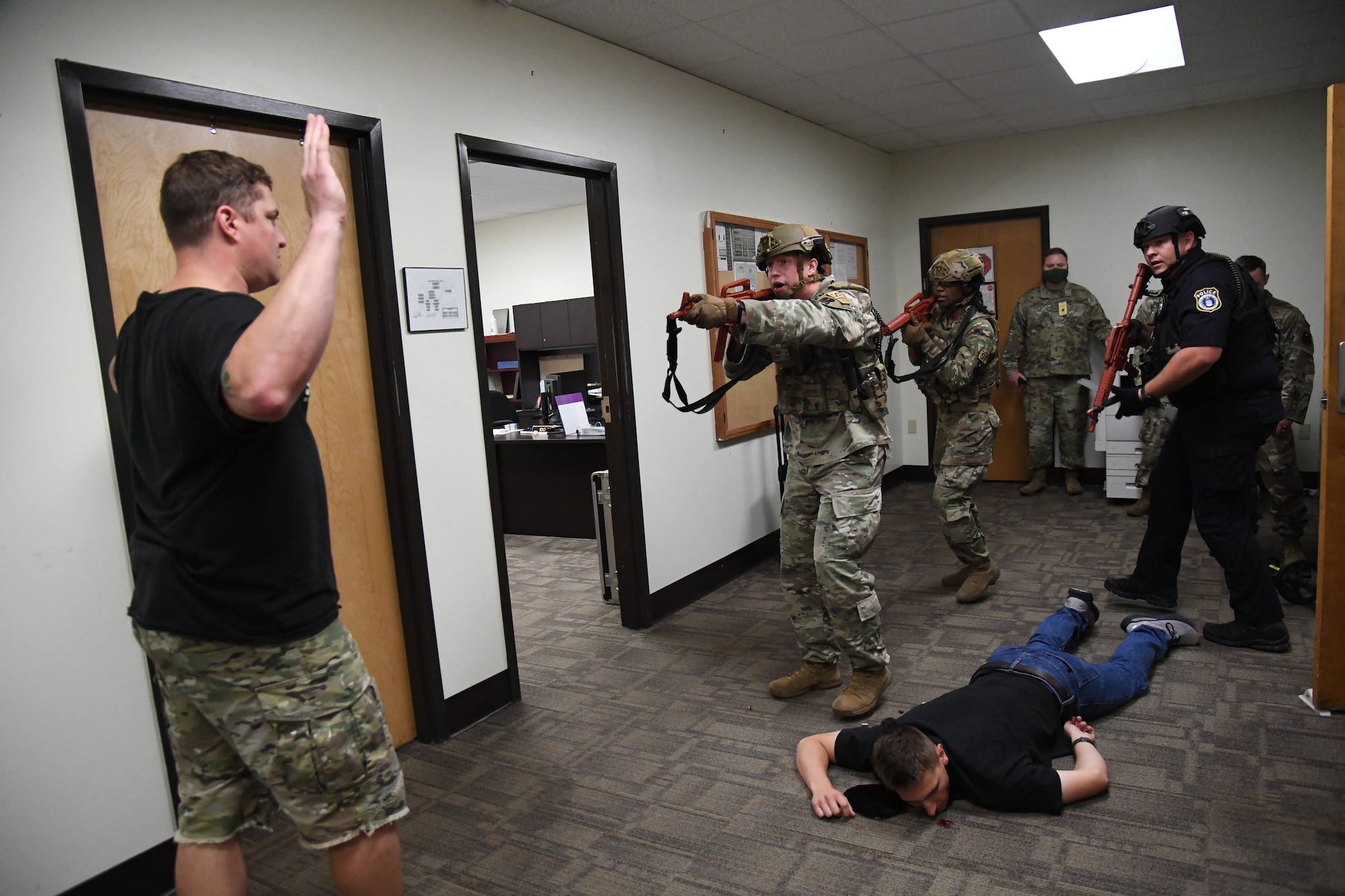 Members of the 81st Security Forces Squadron enter the room to detain U.S. Air Force Staff Sgt. Matthew Storer, 81st Training Support Squadron force development NCO in charge portraying an active shooter, during an active shooter exercise inside the Taylor Logistics Center at Keesler Air Force Base, Mississippi, Oct. 21, 2021. The scenario included an active duty Air Force member who simulated open fire in order to test the base's ability to respond to and recover from a mass casualty event. (U.S. Air Force photo by Kemberly Groue)