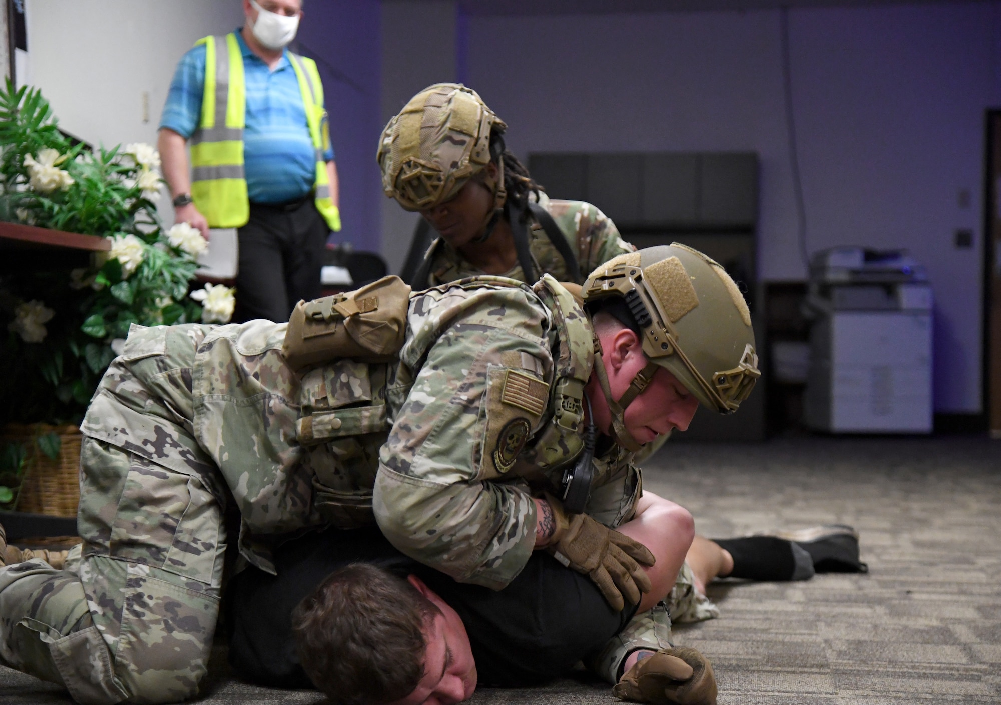 U.S. Air Force Staff Sgt. Bradley Hall, 81st Security Forces Squadron patrolman, and Senior Airman Breanna Thomas, 81st SFS patrolman, detain Staff Sgt. Matthew Storer, 81st Training Support Squadron force development NCO in charge portraying an active shooter, during an active shooter exercise inside the Taylor Logistics Center at Keesler Air Force Base, Mississippi, Oct. 21, 2021. The scenario included an active duty Air Force member who simulated open fire in order to test the base's ability to respond to and recover from a mass casualty event. (U.S. Air Force photo by Kemberly Groue)