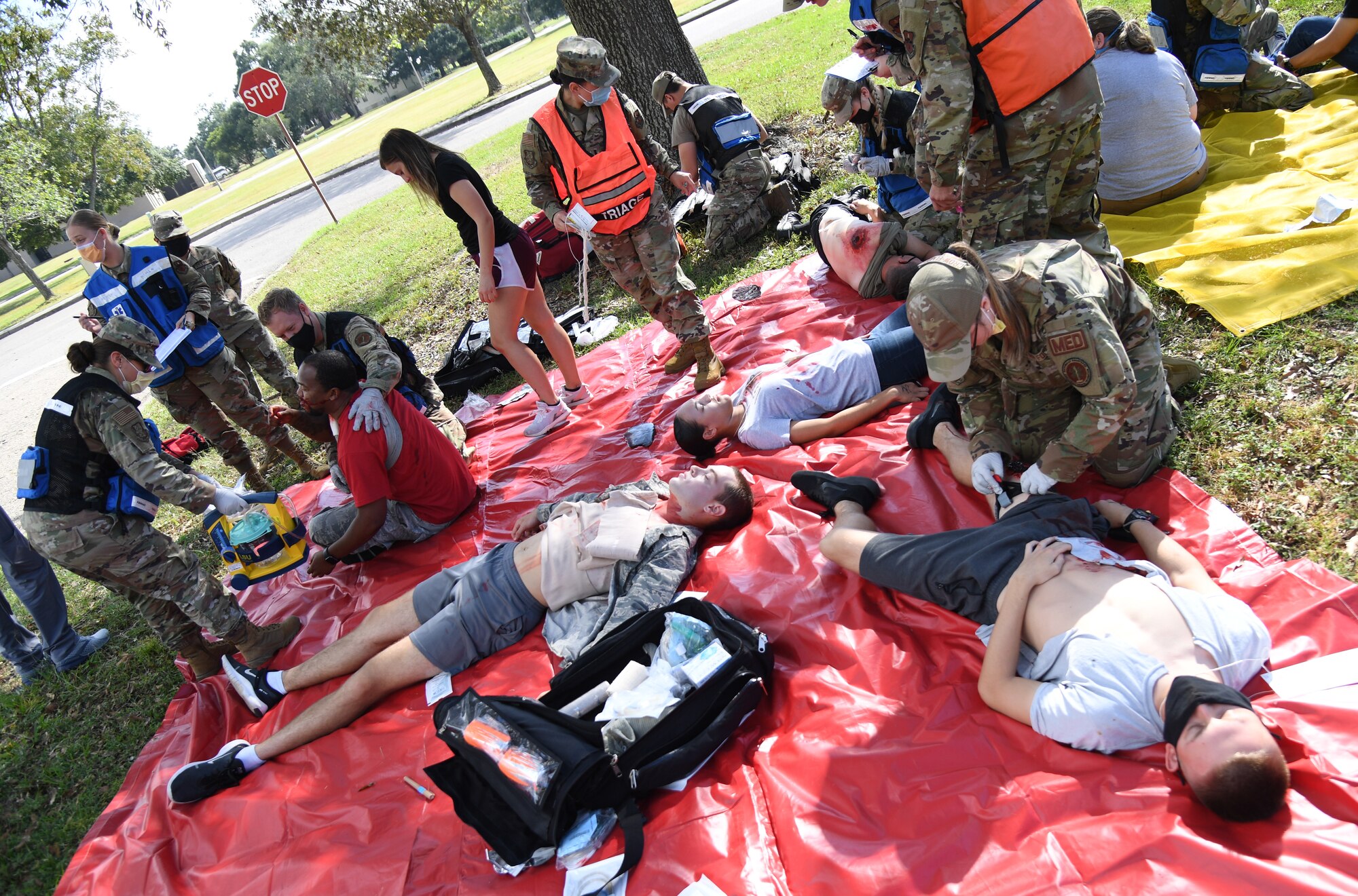 Keesler first responders medically assess actors portraying victims during an active shooter exercise outside the Taylor Logistics Center at Keesler Air Force Base, Mississippi, Oct. 21, 2021. The scenario included an active duty Air Force member who simulated open fire in order to test the base's ability to respond to and recover from a mass casualty event. (U.S. Air Force photo by Kemberly Groue)