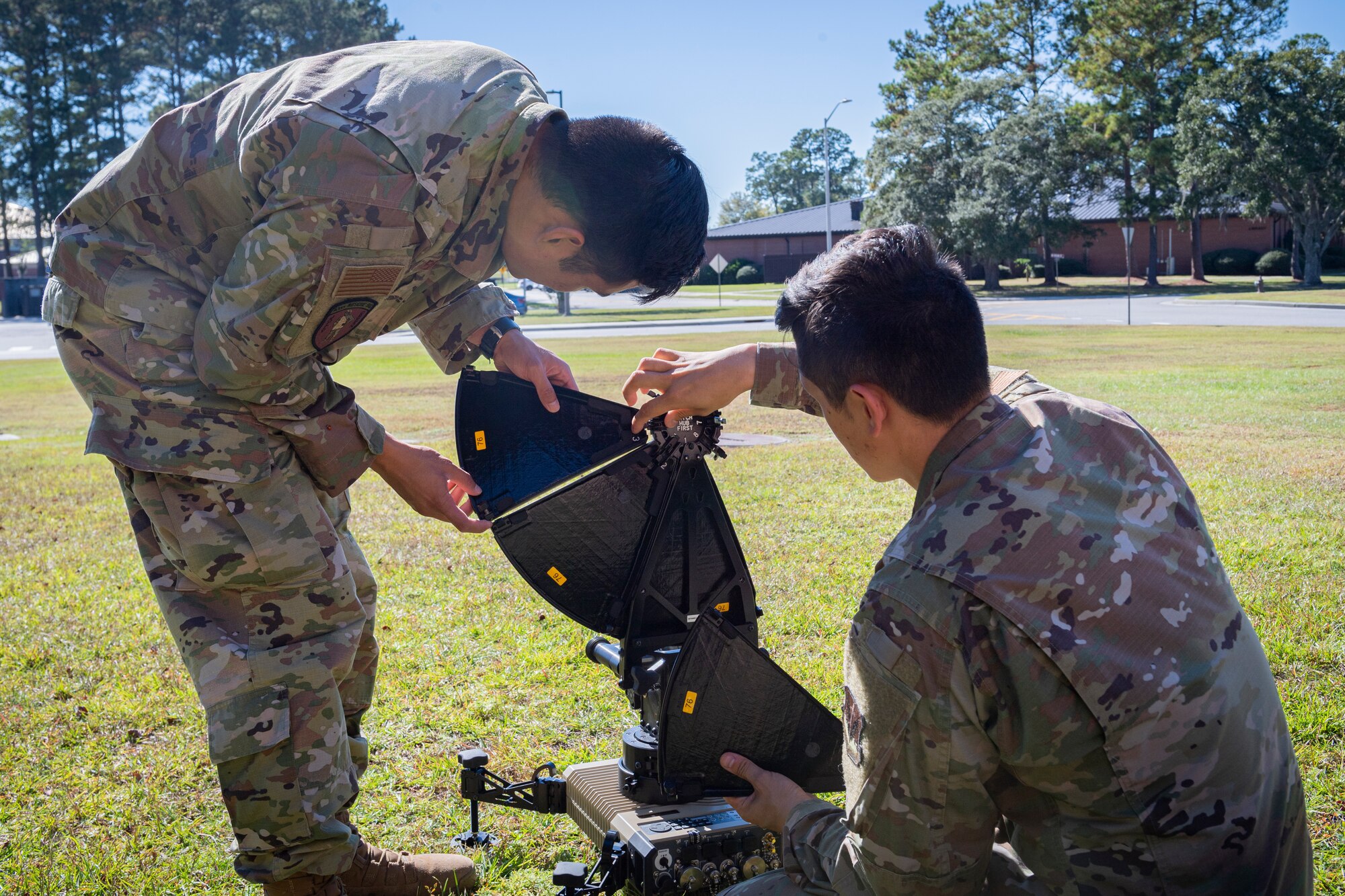 Photo of Airmen attaching hub reflectors to a multi-mission terminal