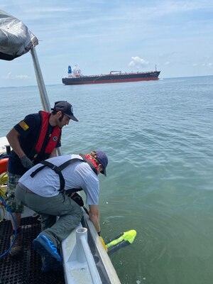 Dr. George Schwarz and Agustin Ortiz deploy the side scan sonar from NHHC research vessel.