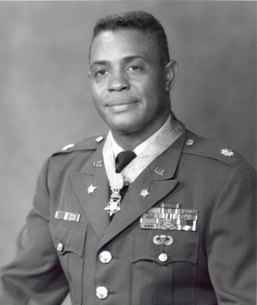 A man in dress uniform poses for an official photo.