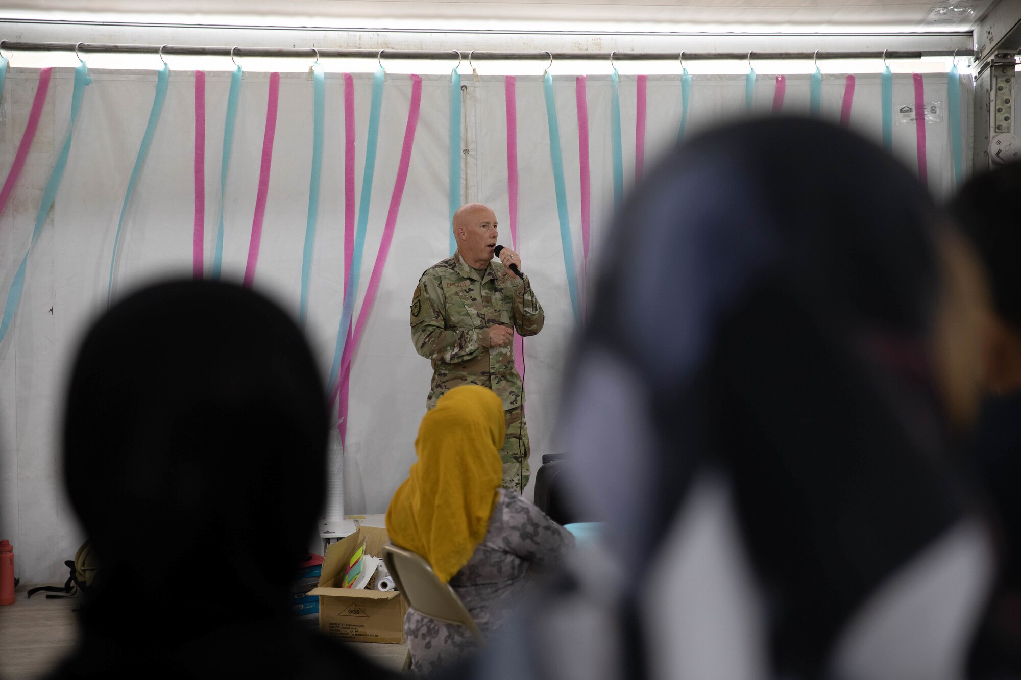 U.S. Air Force Brig. Gen. Daniel Gabrielli, Task Force Holloman commander, speaks to a crowd of Afghan evacuees during the opening of a new education center at Aman Omid Village on Holloman Air Force Base, New Mexico, Oct. 19, 2021. The Department of Defense, through U.S. Northern Command, and in support of the Department of Homeland Security, is providing transportation, temporary housing, medical screening, and general support for at least 50,000 Afghan evacuees at suitable facilities, in permanent or temporary structures, as quickly as possible. This initiative provides Afghan personnel essential support at secure locations outside Afghanistan. (U.S. Army Photo By Pfc. Anthony Ford)