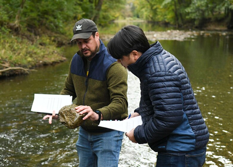 Antioch Middle School science teacher Thomas Yan looks on as USACE Biologist Travis Wiley points out all the aquatic invertebrates living on the surface of a steam rock, giving clear indication on the lake's healthy water quality at Drakes Creek Park in Hendersonville, TN.