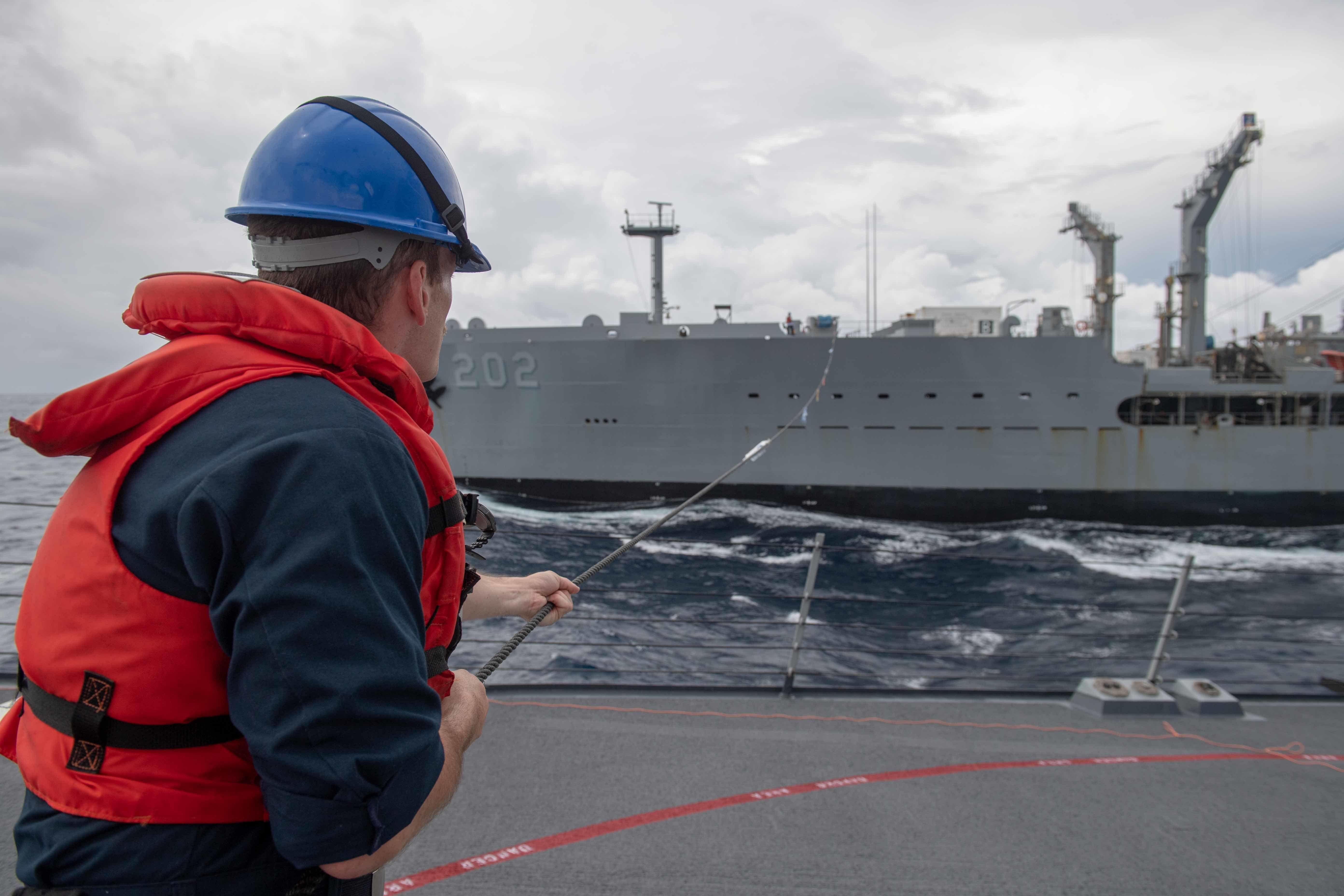 Fire Controlman (Aegis) 3rd Class Tyler Hansen, from Phoenix, Ariz.,  handles a phone and distance line on the forecastle of Arleigh Burke-class guided-missile destroyer USS Higgins (DDG 76).