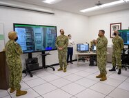 During the tour for Vice Adm. Kelly Aeschbach, commander, Naval Information Forces (left), Capt. Marc Ratkus, commander, Center for Information Warfare Training (right), commented on the cost savings of using the Multipurpose Reconfigurable Training Systems (MRTS) 3D trainers during the demonstration of the AN/SLQ-32 (V)6 MRTS by Cryptologic Technician Technical 1st Class Zachery Oconnor, maintenance course supervisor for the AN/SLQ-32 (V)6 (center).