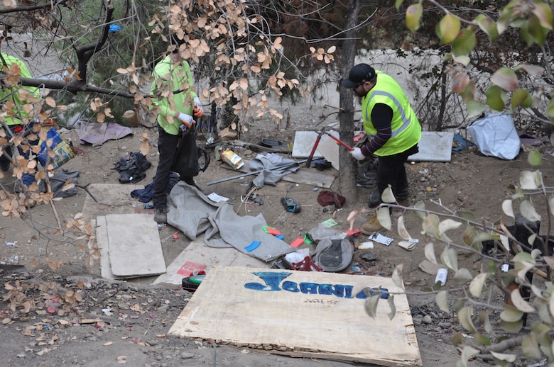 Workers remove trash from an abandoned homeless encampment, Sept. 27, 2021, near Whittier, California, as part of a two-week cleanup by the U.S. Army Corps of Engineers Los Angeles District. About 120 acres of creek and riverbank were cleared during the project.