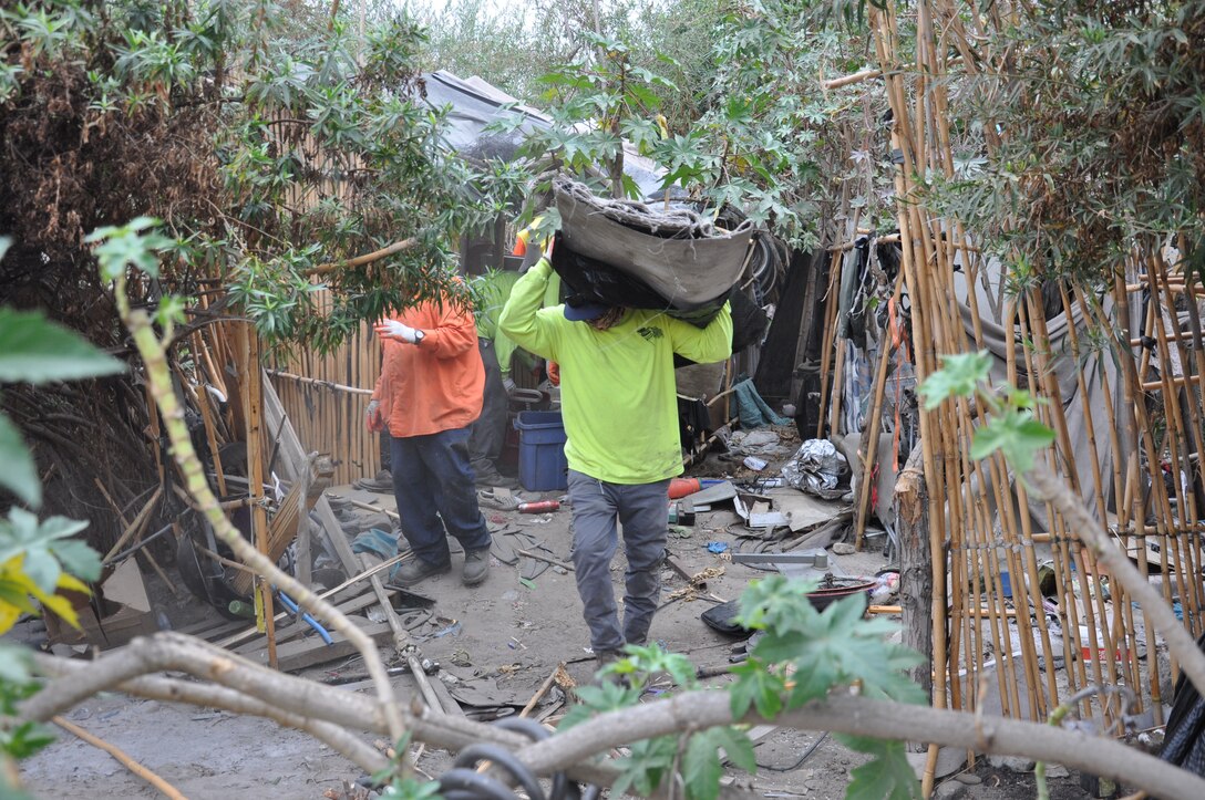 Workers remove trash from an abandoned homeless campsite, Sept. 27, 2021, near Whittier, California, as part of a two-week cleanup by the U.S. Army Corps of Engineers Los Angeles District. About 120 acres of creek and riverbank were cleaned, removing a whopping 575 tons of debris during the project.