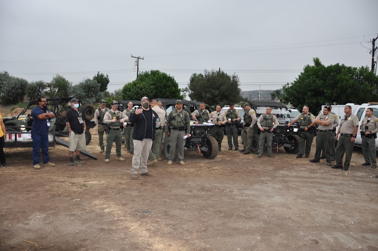 U.S. Army Corps of Engineers Los Angeles District project manager Trevor Snyder, foreground, briefs an early morning assembly of law enforcement, social services and community partners before the start of the two-week project, Sept. 27, in Whittier, California. The Corps cleared about 120 acres of riverbank.