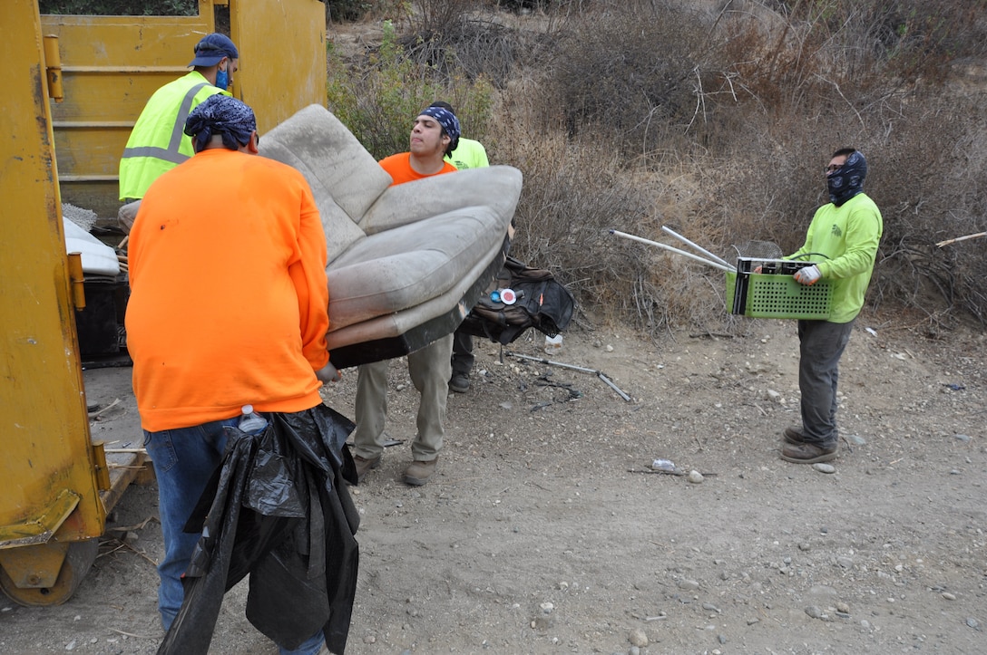 Workers queue-up to dump car seats and other debris found used during the San Gabriel River and San Jose Creek cleanup into one of 82 dumpsters, Sept. 27-Oct. 22, 2021. A total of 575 tons of debris were removed during the two-week project. The U.S. Army Corps of Engineers Los Angeles District cleared about 120 acres of riverbank.