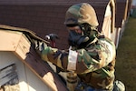 Alaska Air National Guard Senior Airman James Donadio, a 176th Civil Engineer Squadron structural specialist, repairs a shed Oct. 24, 2021, during task qualification training under simulated chemical, biological, radiological and nuclear conditions at Joint Base Elmendorf-Richardson. Headquarters Air Force requires the squadron to complete tasks under CBRN conditions across the squadron's career fields.