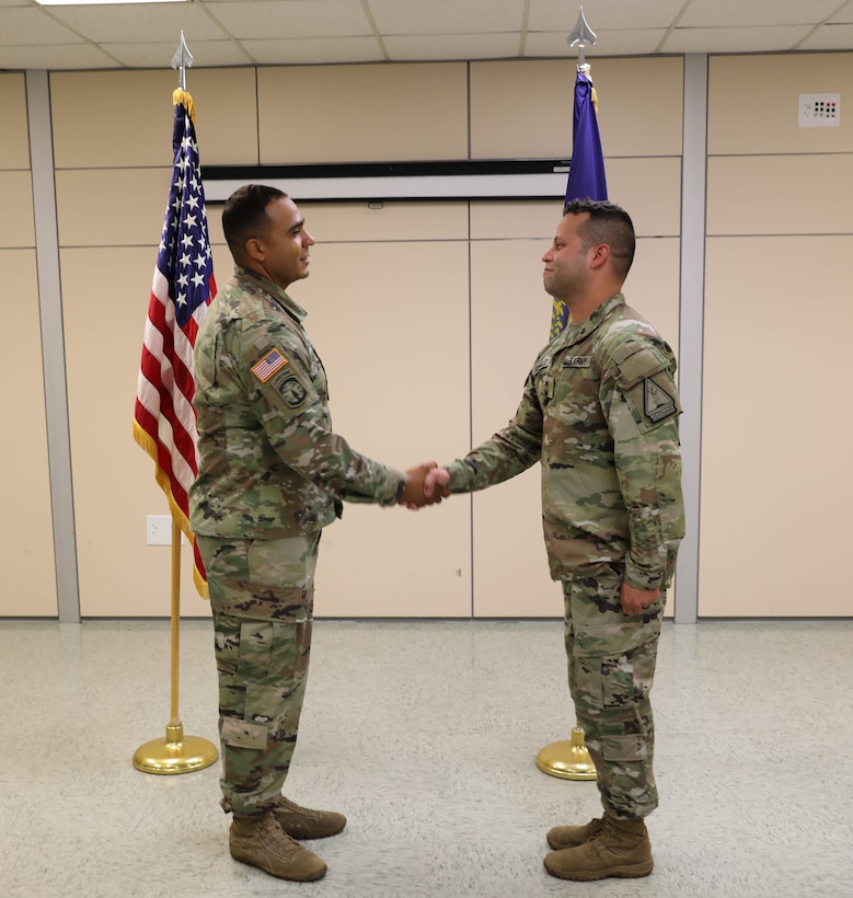 2nd Lt. Orlando Gonzalez shakes hands with Master Sgt. Kristofer Serna after receiving his first salute Sept. 24, 2021, at Bowman Field Armory, during Gonzalez searing in ceremony. Gonzalez ended his 16 years of military service as an enlisted service member to begin his officer career.