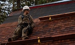 Airman 1st Class Darian Montalvo, 152nd Civil Engineer Squadron power production specialist, stands on the roof of a historical cabin during a reroofing project at the Tallac Historical Site, South Lake Tahoe, Calif., Oct. 21, 2021. Airmen worked on the project for six days, continuing a 38-year history of training at the site.