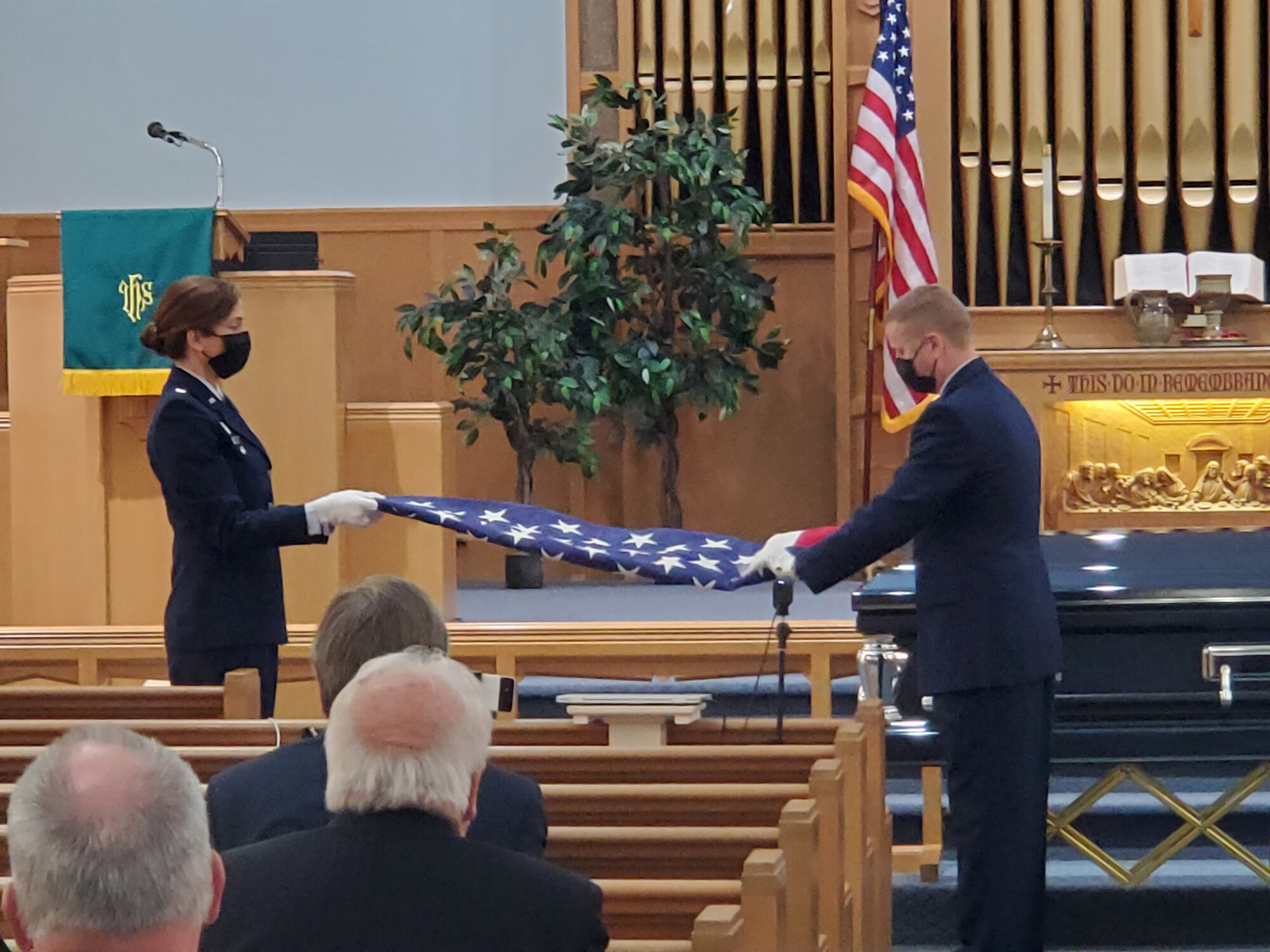 Lt. Col. (retired) Dianne Hickey, former 14th Intelligence Squadron commander, and Maj. Andrew Soine, 14 IS director of operations, fold a flag as part of the military honors conducted during World War II veteran John “Jerry” Johnson’s funeral Oct. 23, 2021. Senior Master Sgt. Jonathon Washington performed Taps during the service. Johnson had served in Guam during World War II with the Army Air Corps in the 20th Air Force 9th Photographic Technical Squadron. His squadron ultimately became the 14 IS.