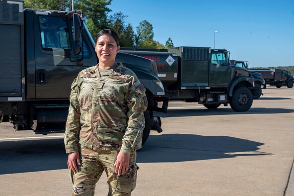 An Airman stands in front of a aircraft refueling vehicle.