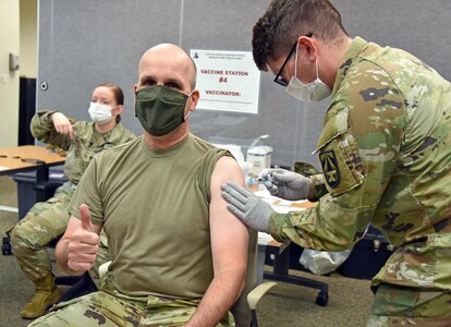 Col. Timothy Walsh, deputy commander for U.S. Army Medical Logistics Command, receives his influenza vaccine during a clinic Oct. 27 at Fort Detrick, Maryland. Administering Walsh's flu shot is Spc. Neal Burnett, healthcare specialist for U.S. Army Medical Research Institute of Infectious Diseases.