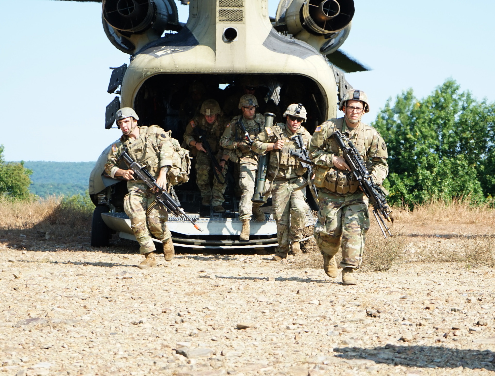 Soldiers in the 11B3O Advanced Leader Course disembark from a CH-47 Chinook and move to perform security around the helicopter during their field training exercise at Fort Indiantown Gap, Pa., on Aug. 13, 2021. The Soldiers, led by the cadre from 166th Regiment Regional Training Institute, will be graded on their abilities to lead and community during different scenarios in the field.