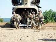 Soldiers in the 11B3O Advanced Leader Course disembark from a CH-47 Chinook and move to perform security around the helicopter during their field training exercise at Fort Indiantown Gap, Pa., on Aug. 13, 2021. The Soldiers, led by the cadre from 166th Regiment Regional Training Institute, will be graded on their abilities to lead and community during different scenarios in the field.