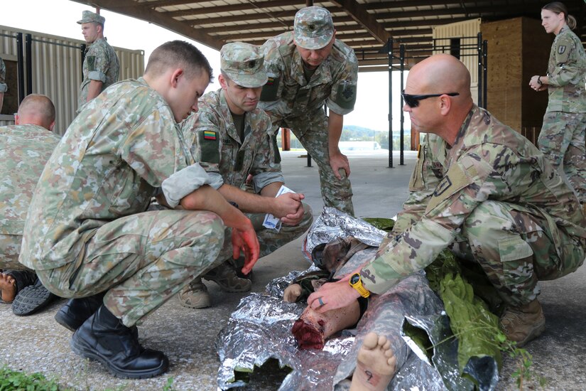 Sgt. 1st Class Dale Mahafkey, an Army combat medic and senior instructor with Medical Battalion Training Site at Fort Indiantown Gap, Pa., coaches Lithuanian Soldiers as they treat a simulated casualty on Sept. 10. Thirty-three Soldiers from Lithuania’s land forces reserve component came to Fort Indiantown Gap Sept. 6-17 for an annual platoon exchange, part of the Pennsylvania National Guard’s State Partnership Program.