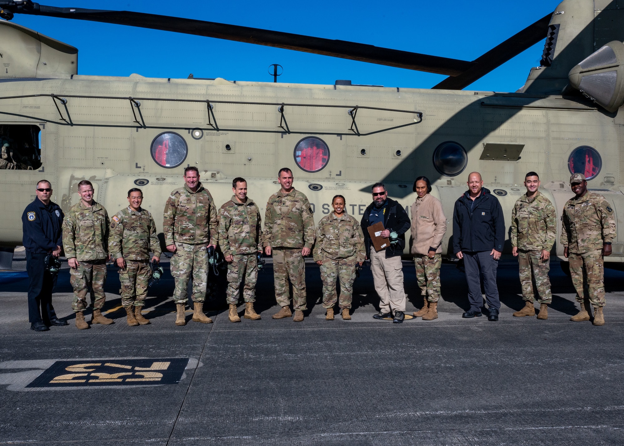 JBLE Command team poses in front of a CH-47 Chinook rotary aircraft.