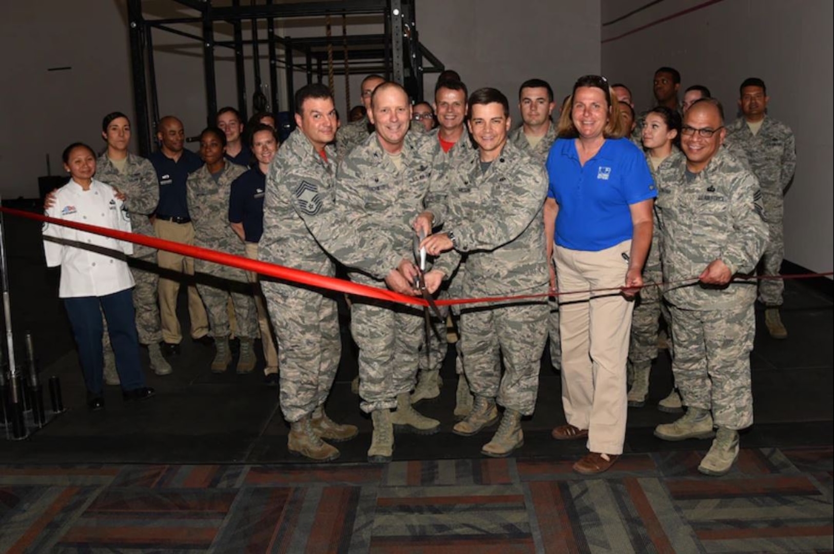 PETERSON AIR FORCE BASE, Colo. - Col. Doug Schiess, 21st Space Wing commander, along with Airmen from the 21st Civil Engineer Squadron and 21st Force Support Squadron, cuts the ribbon for the grand opening of 24-hour fitness at the Fitness Center, Peterson Air Force Base, Colo., June 16, 2017. Military ID registration for 24/7 access is now available at the Fitness Center. (U. S. Air Force photo by Robb Lingley)