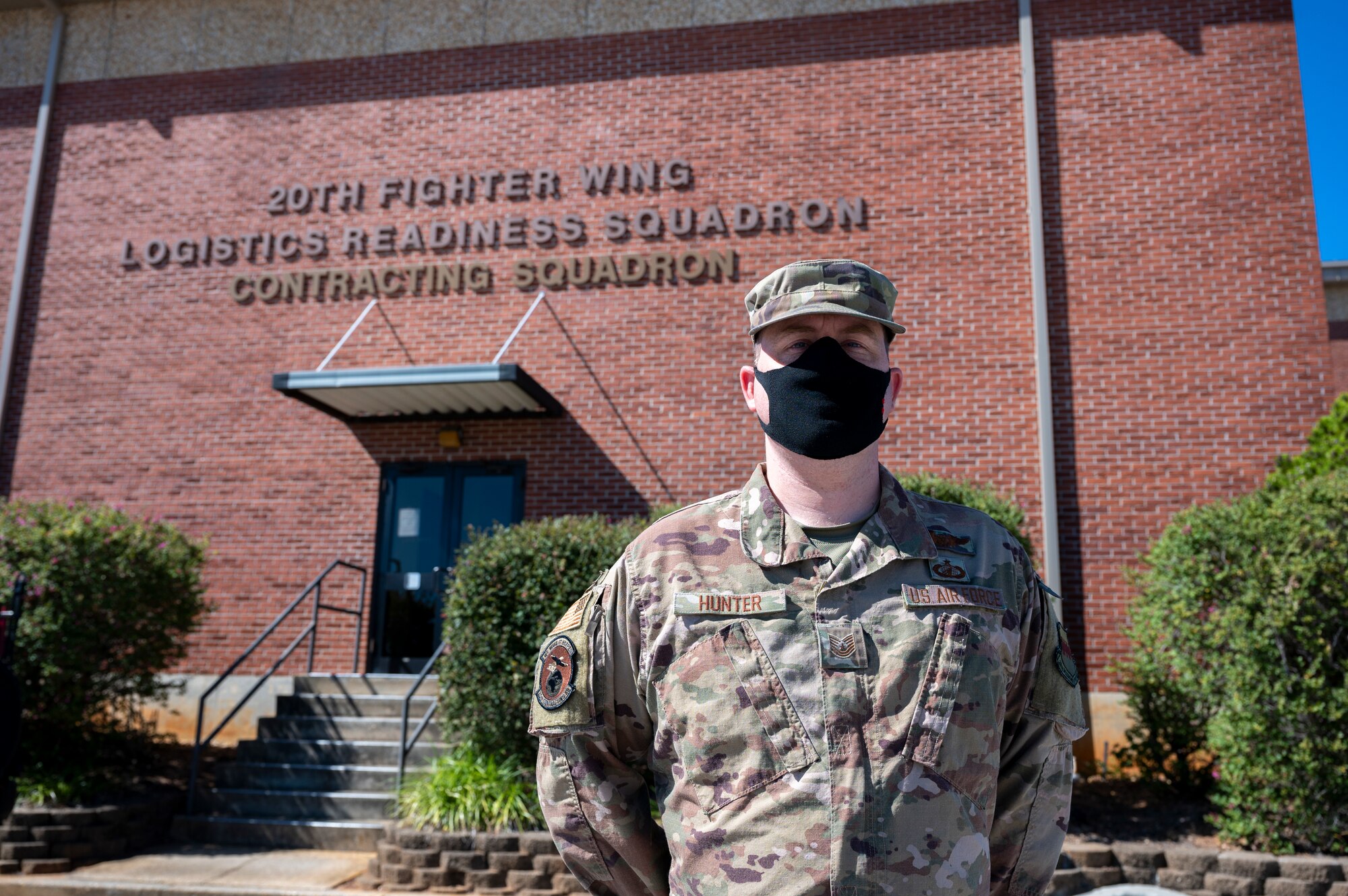 An Airman is photographed in front of his squadron.