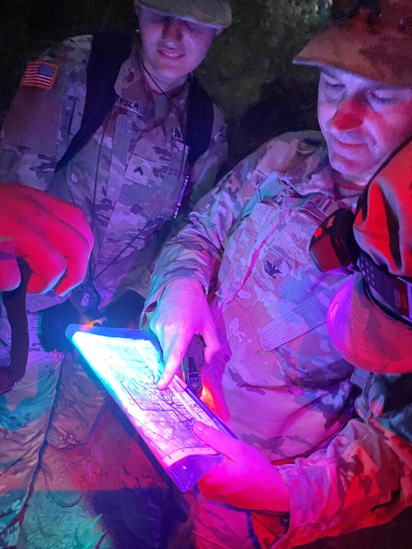 Col. Aristotle Vaseliades, commander, Bayne-Jones Army Community Hospital, confirms point location on map as his team plots their route during the night land navigation course on Oct. 22, at the Joint Readiness Training Center and Fort Polk, La.