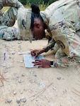 Cpl. Kenaura Warren, laboratory technician, Bayne-Jones Army Community Hospital, uses a protractor and grid coordinates to plot her route during the night land navigation course on Oct. 22, at the Joint Readiness Training Center and Fort Polk, La.