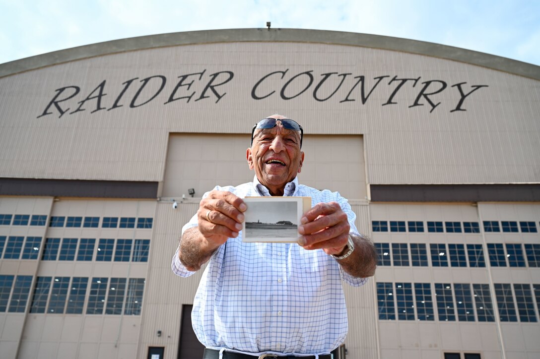 Fred Solomon, former Airman, poses with a photograph of the Pride Hangar he took in 1952 in front of the Pride Hangar at Ellsworth Air Force Base, S.D., Sept. 14, 2021. Solomon was stationed at Ellsworth from 1951 until 1955 and had the opportunity to revisit the base with his son, Mark. (U.S. Air Force photo by Staff Sgt. Hannah Malone)