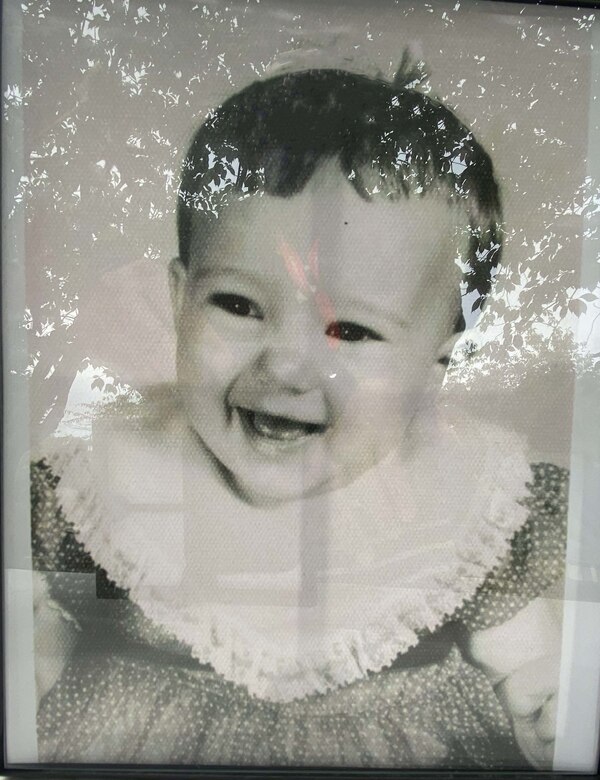 A black and white photo of Victoria "Vickie" Shepard as a baby on display on the memory table.