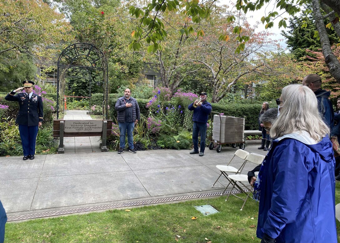 Photo of family, friends and coworkers of Victoria "Vickie" Shepard standing at attention as "Taps" was played during a memorial in her honor.