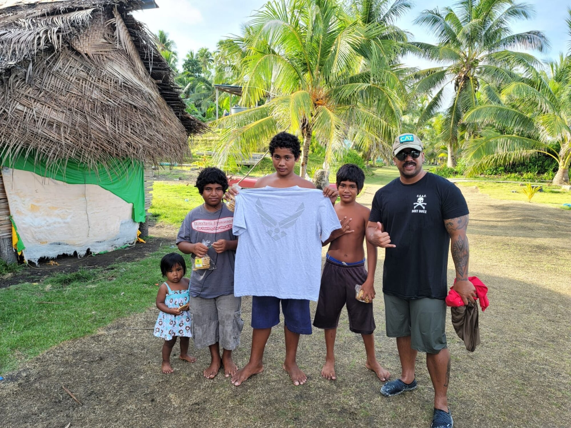 A Member of the Civic Action Team Palau stands with local children of Palau during an outreach event. The CAT is working with locals on community projects, apprenticeship training, vehicle maintenance, medical support and construction. They will be on island into the New Year.  Some community events include cultural fairs, House of pain, beach clean-ups, reading to students and more. House of pain is a daily workout the CAT does with the locals to promote unity in the community while supporting the islands "Fit Palau" initiative. (Courtesy Photo)