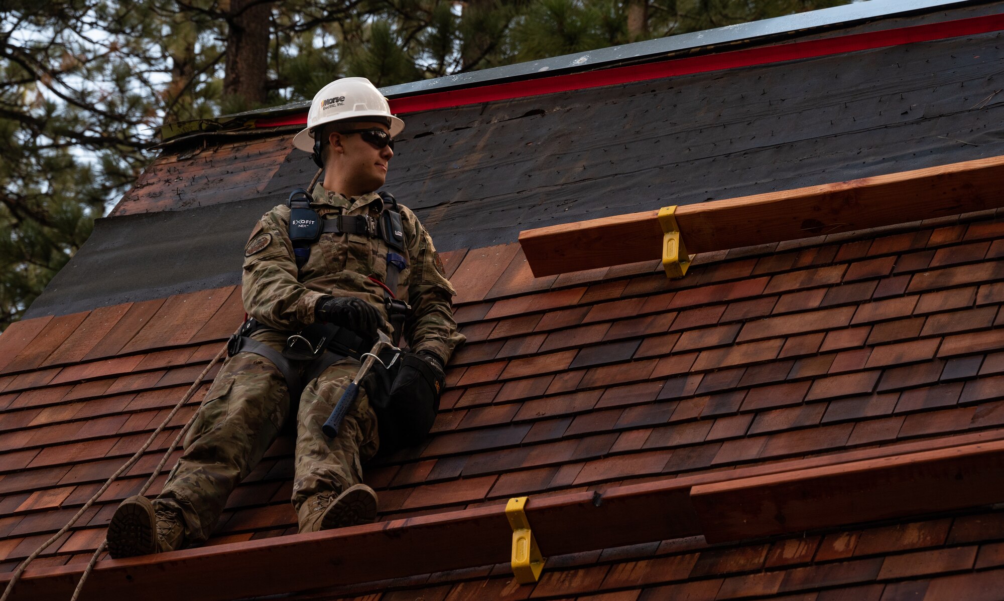 Airman 1st Class Darian Montalvo, 152nd Civil Engineer Squadron power production specialist, stands on the roof of a historical cabin during a reroofing project at the Tallac Historical Site, South Lake Tahoe, Calif., Oct. 21, 2021. Airmen worked on the project for six days, continuing a 38-year history of training at the site.