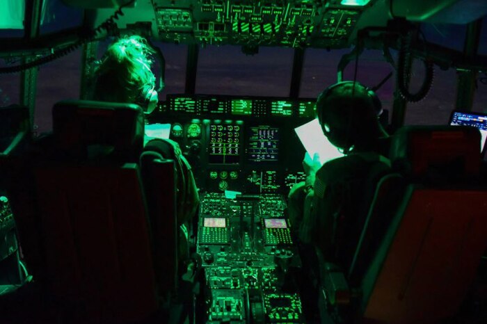 Two pilots sit in a cockpit.