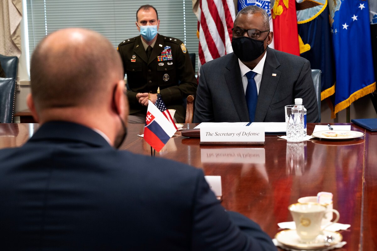 Two men look at each other across a table.