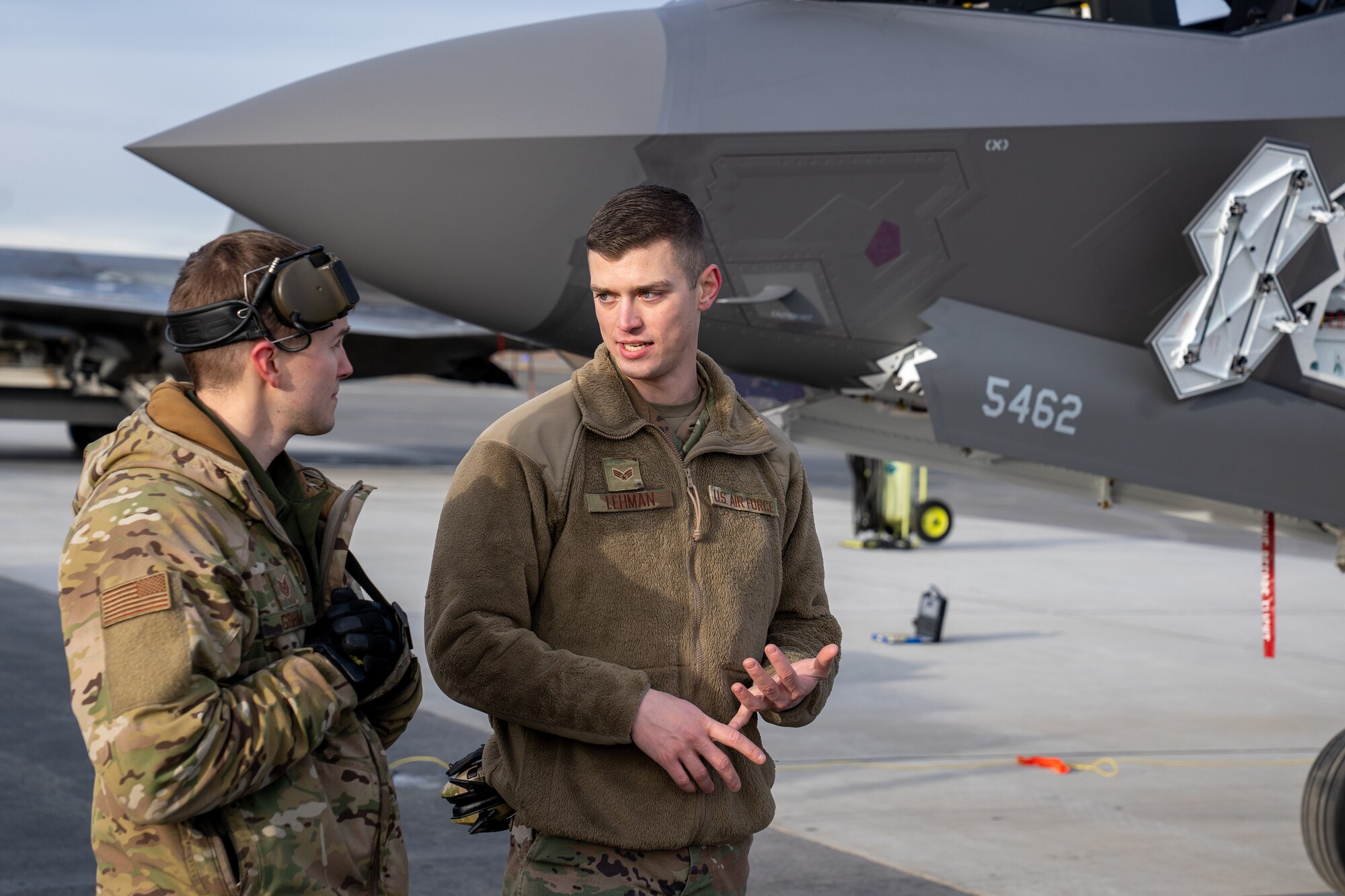 U.S. Air Force Tech. Sgt. Christopher Graham, a 477th Aircraft Maintenance Squadron flight chief, and Senior Airman Adam Lehman, a 354th Aircraft Maintenance Squadron crew chief, discuss maintenance procedures for an F-35A Lightning II.